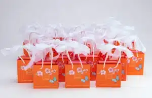 A collection of small orange jewelry bags tied with a white ribbon
