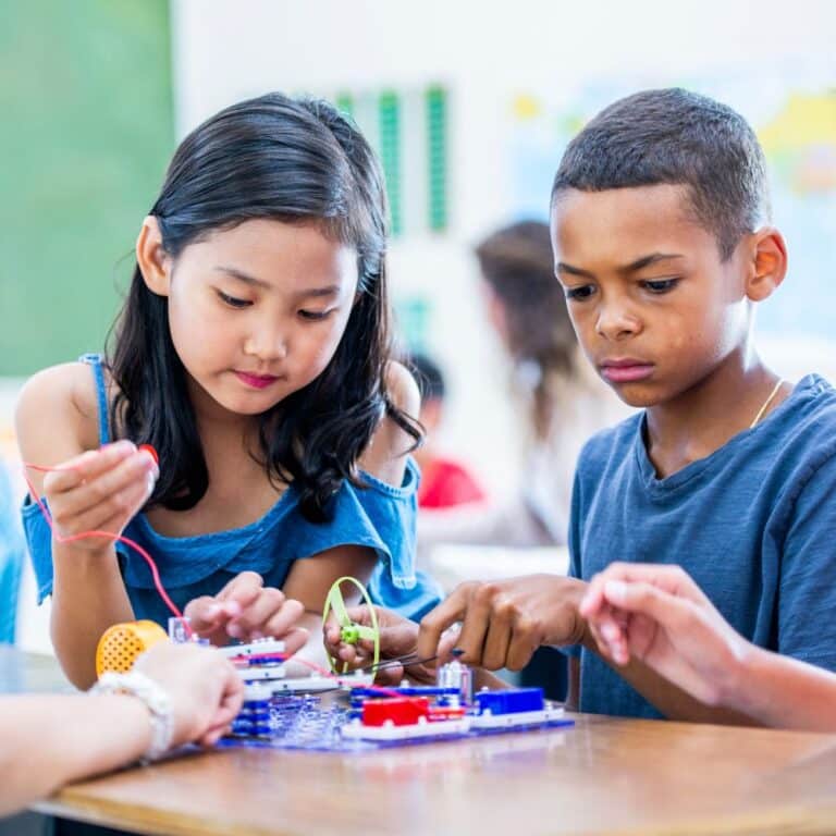 Two children working together on an electronics project